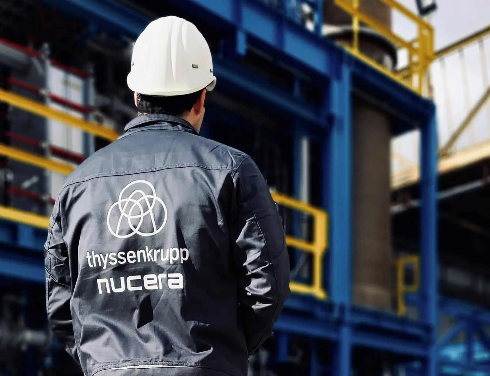 thyssenkrupp nucera employee standing in front of the module yard