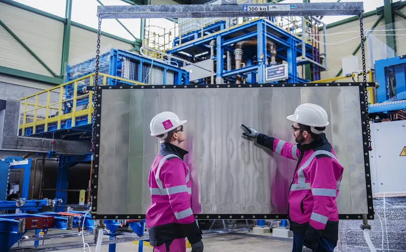 Two engineers looking at an electrolysis cell