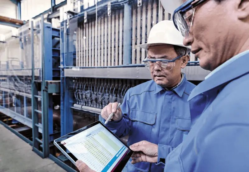 employees talking in front of electrolyzers